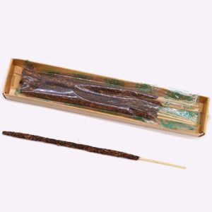 Pojedyncze naturalne kadzidełko masala Nag Champa o widocznej ziołowej strukturze leżące przy otwartym opakowaniu